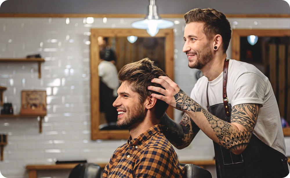Friseur frisiert am Kunden seine Haare